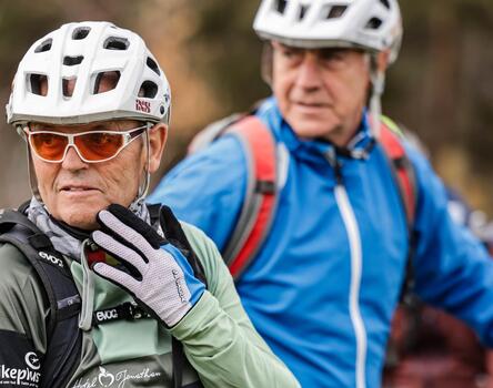 Due uomini con il casco da bici sono seduti sulle loro biciclette