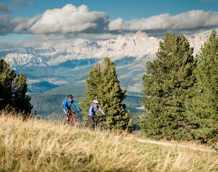 Un uomo e una donna percorrono in bicicletta una strada forestale