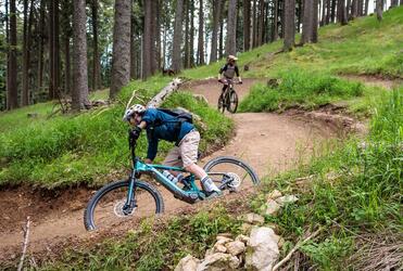 Two people are riding down a trail