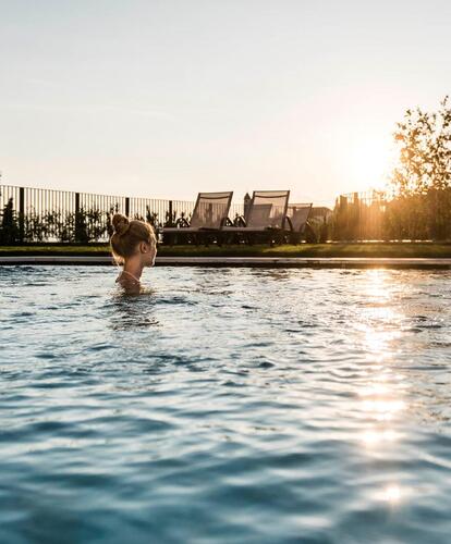 Two women relax in the outdoor pool at Hotel Erica