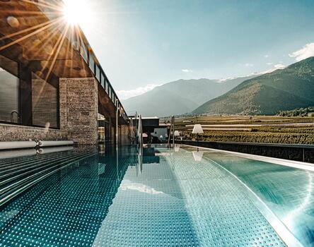 Exterior view of the pool with a view of the surrounding sunlit valley and mountains in the background.