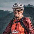 Nahaufnahme des Gastgebers Toni in roter Fahrradkleidung und Helm.