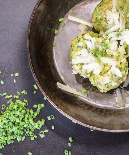 Canederli agli spinaci serviti con formaggio ed erba cipollina