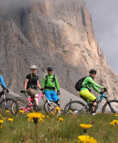 Quattro persone con biciclette davanti alle Dolomiti