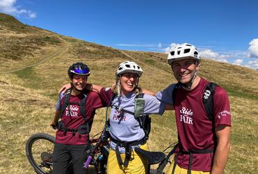 Tre ciclisti con le loro biciclette davanti a un paesaggio alpino