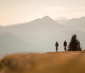 Zwei Radfahrer fahren auf einem Schotterweg in den Bergen
