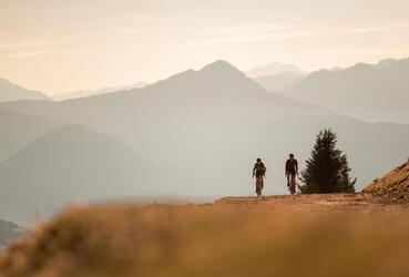 Due ciclisti pedalano su una strada sterrata in montagna