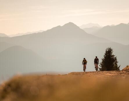 Due ciclisti pedalano su una strada sterrata in montagna