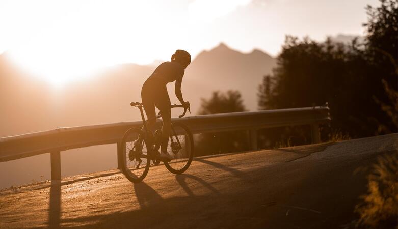 Un ciclista su strada al tramonto