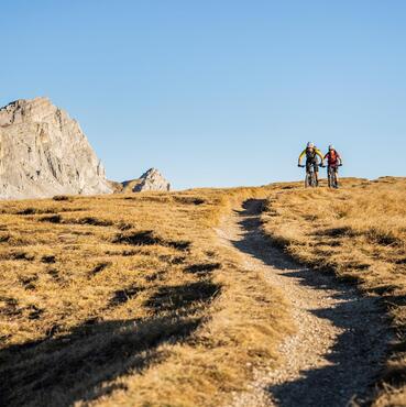 Zwei Mountainbiker fahren einen Trail in Alta Badia Pralongia