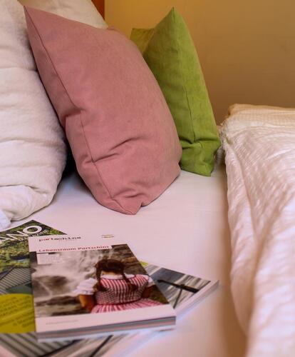 The magazine “Merano” lies on a bed
