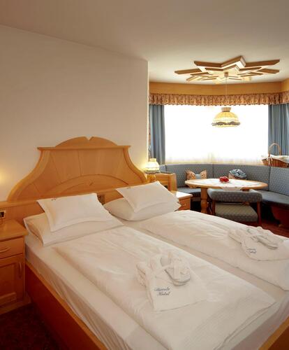 Hotel room at Hotel Piccolo with a double bed, wooden furniture and a sitting area by the window.