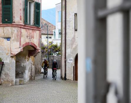 Zwei Radfahrer fahren durch eine schmale Gasse