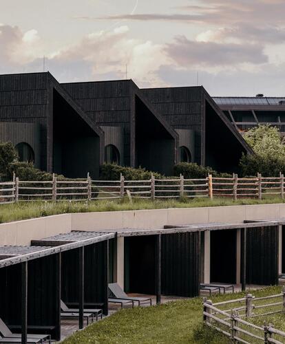 Das moderne Bikehotel Pföstl mit dunkler Holzfassade und begrünten Dächern.