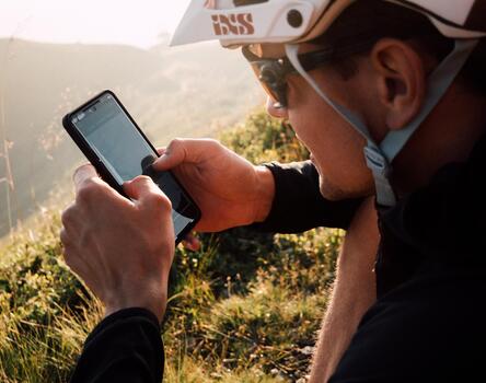 A mountain biker looks at his smartphone