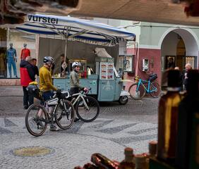 Two cyclists are in the old town of Merano