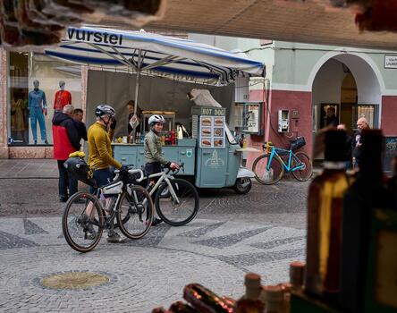 Zwei Fahrradfahrer sind in der Altstadt von Meran unterwegs