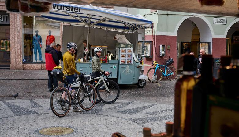 Two cyclists are in the old town of Merano