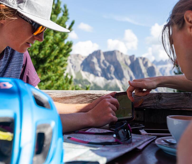 Zwei Frauen schauen sich eine Karte auf dem Smartphone an