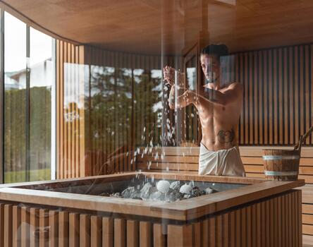 A sauna master prepares an infusion in the sauna